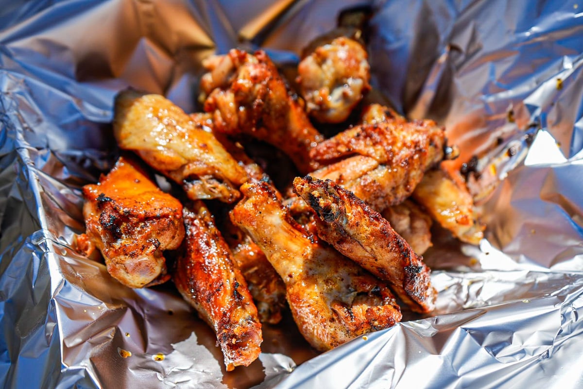 Grilled chicken skewers with golden-brown, seasoned exterior on aluminum foil